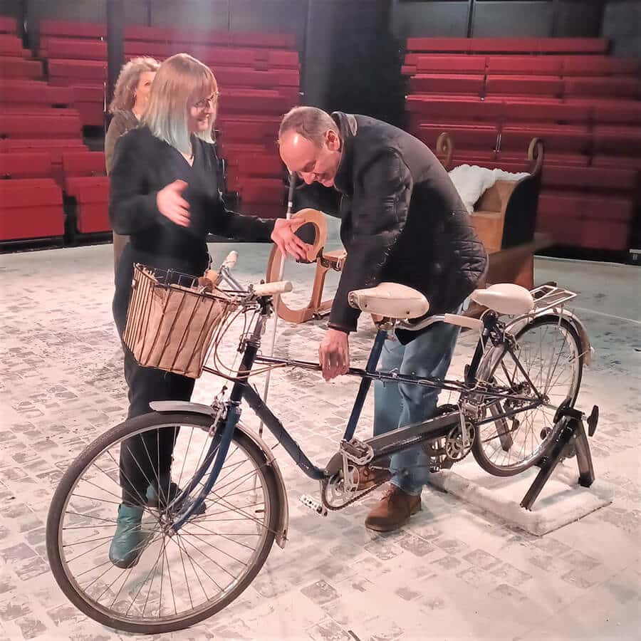 Charlotte working with a visual impaired audience member on a theatre touch tour, examining the set on stage.